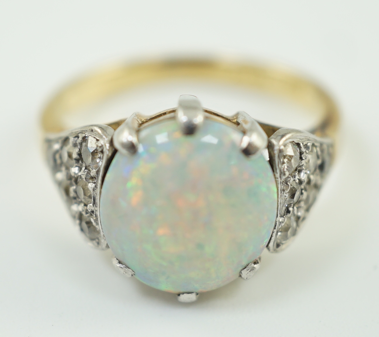 An 18ct gold and single stone white opal set ring, with twelve stone diamond set shoulders